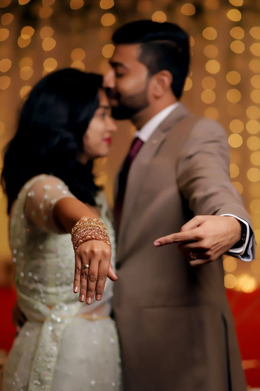 Couple standing close together against warm blurred lights
