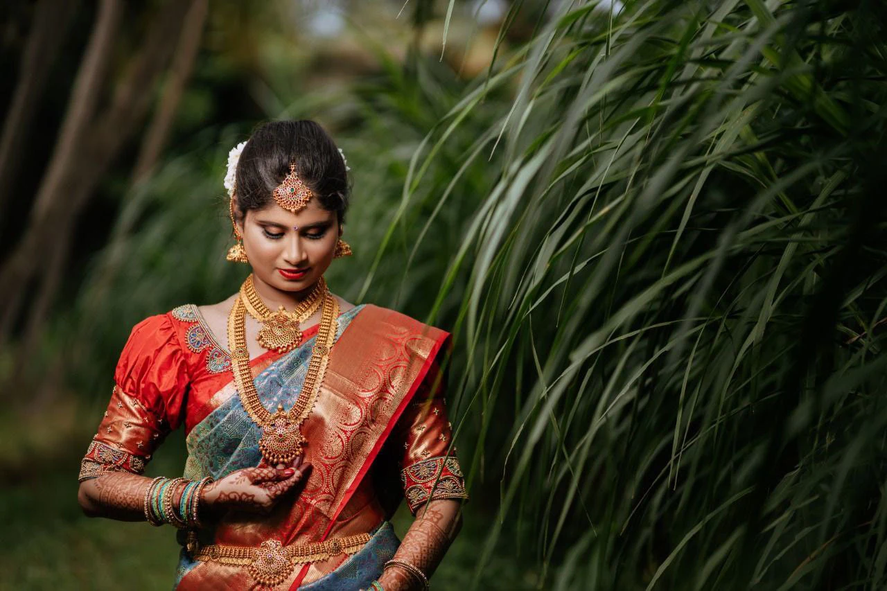 Portrait of a woman framed by long green leaves