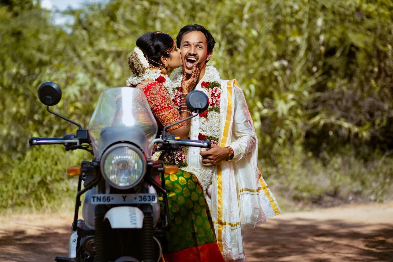 Couple laughing together beside a motorcycle