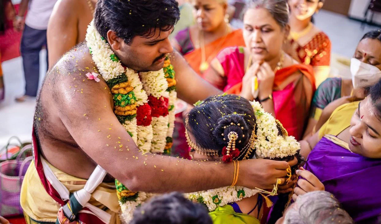 Couple leaning towards each other while surrounded by people