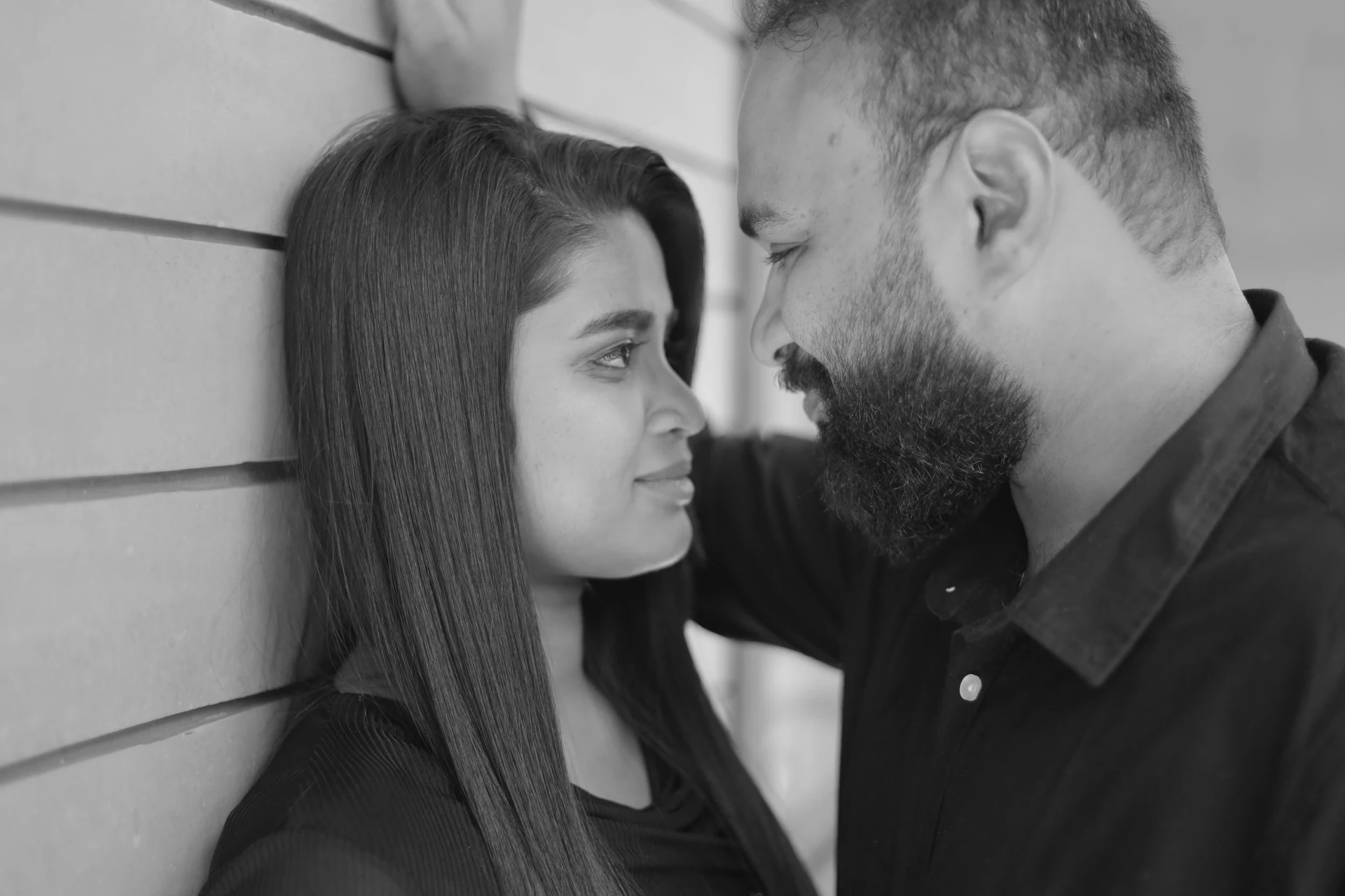 Black-and-white close portrait of a couple touching foreheads