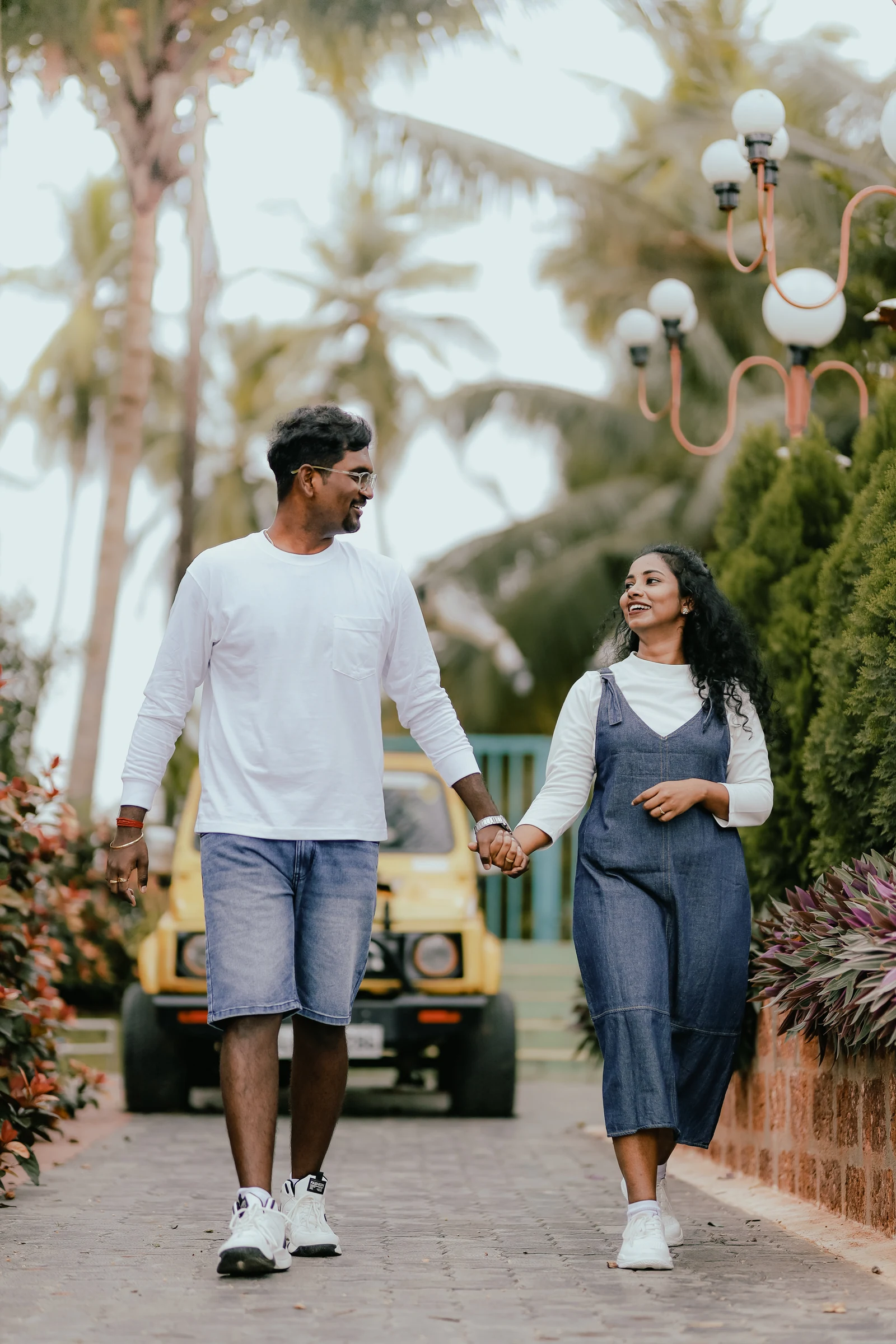 Couple holding hands as they walk along a garden path