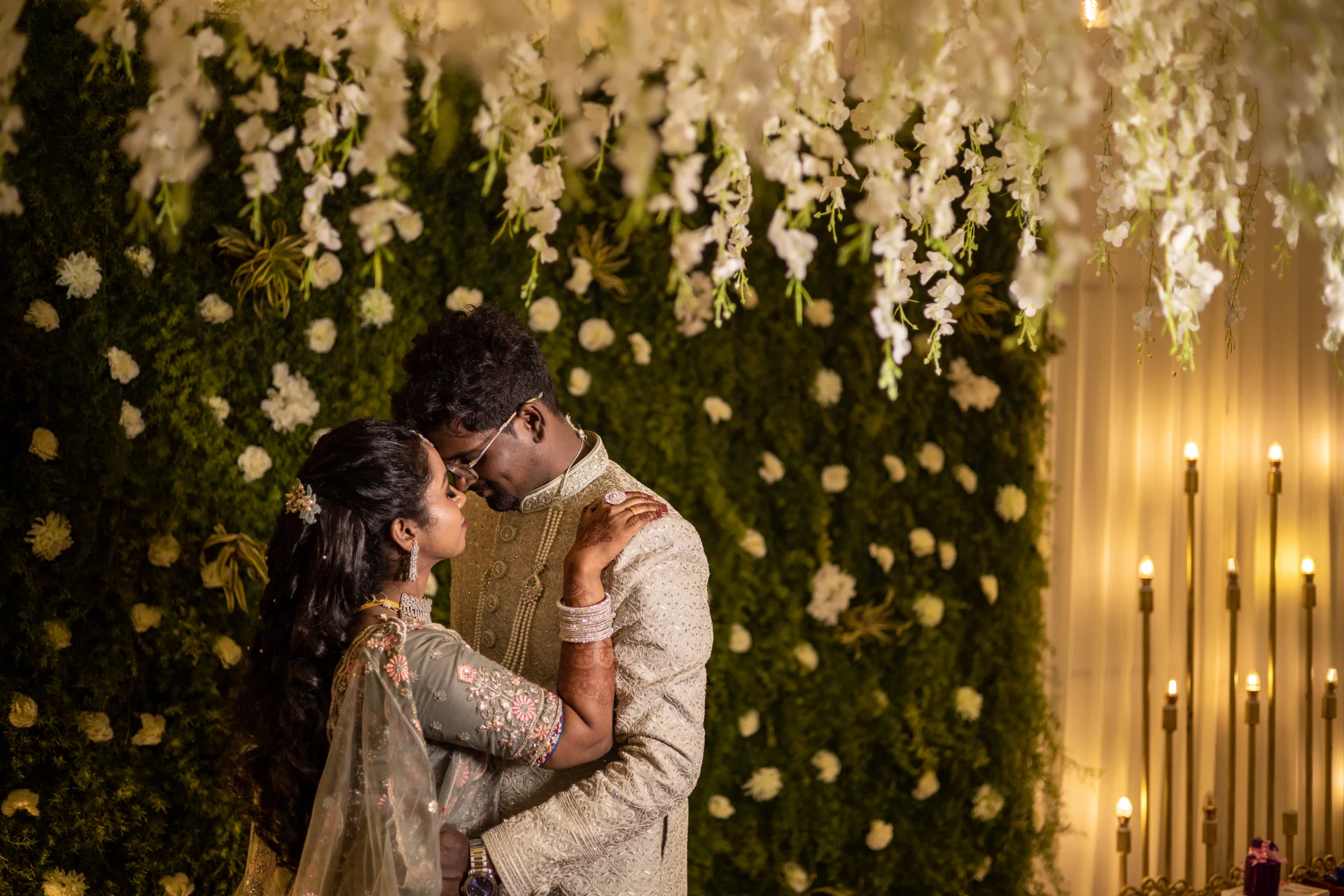 Couple sharing a quiet moment beneath hanging white flowers