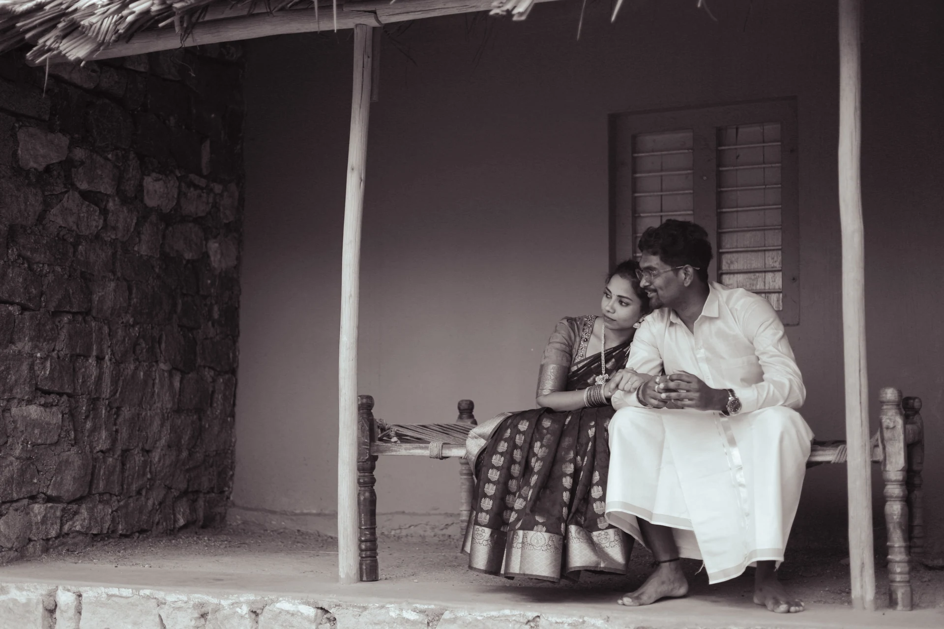 Couple sitting close together on a shaded veranda