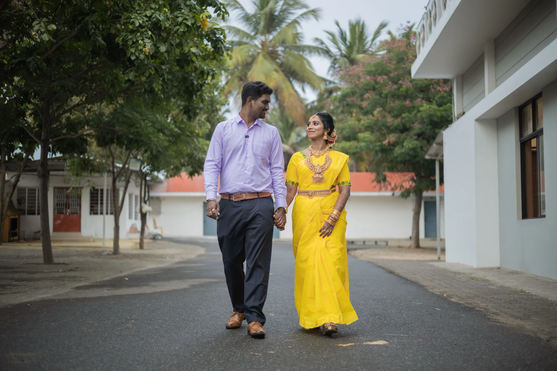 Couple walking together along a quiet palm-lined street