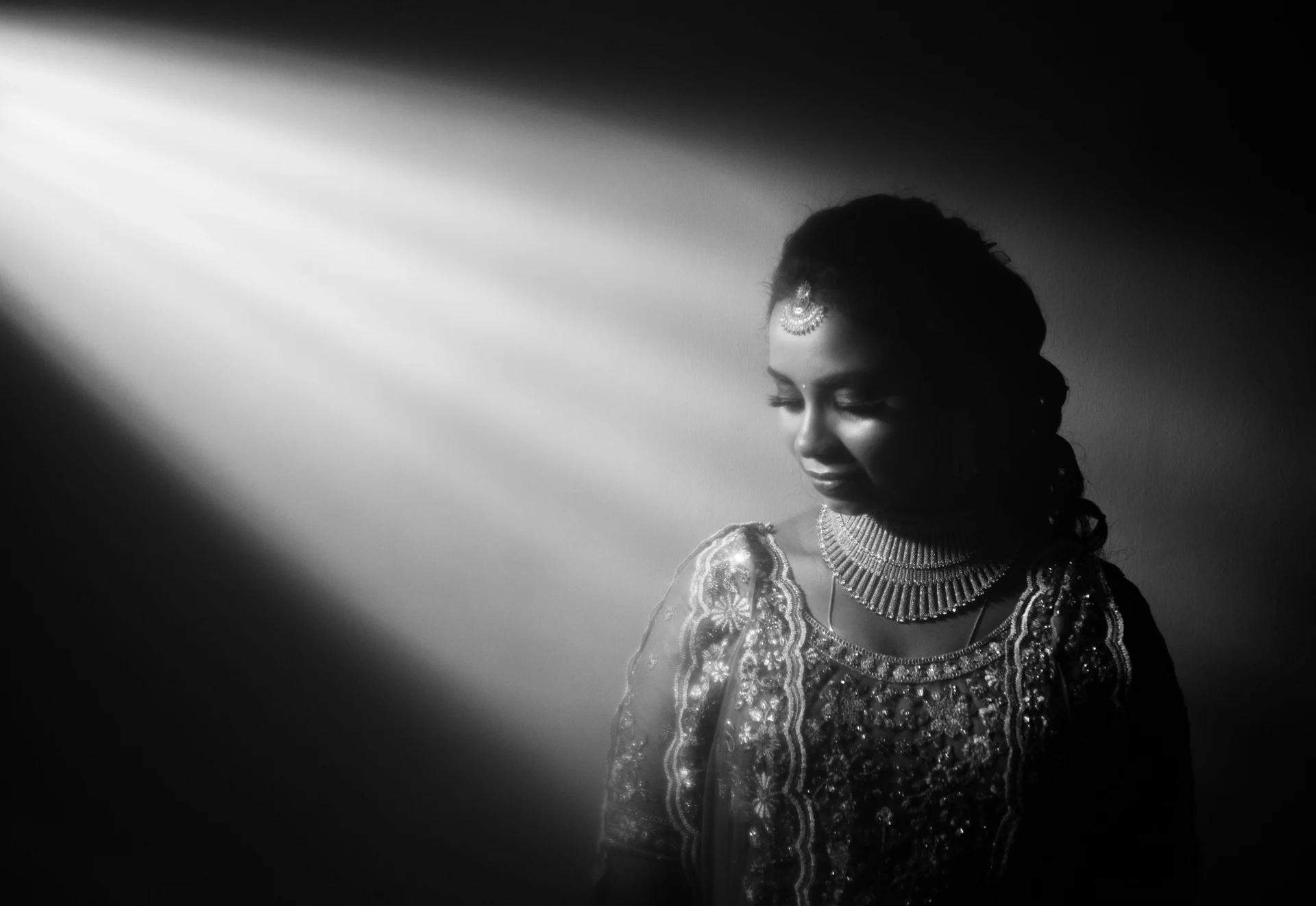 A woman looking towards her reflection in soft window light