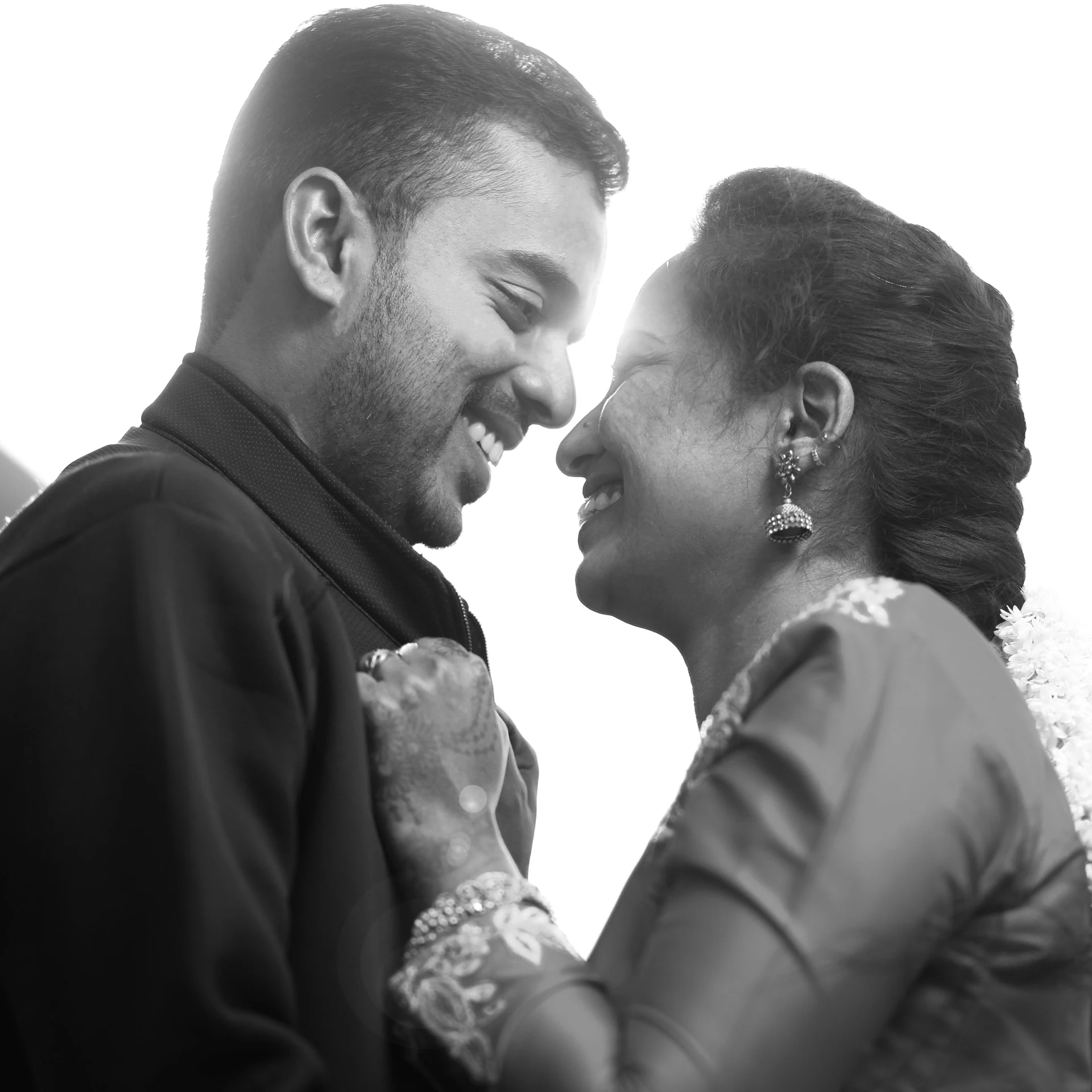 Black-and-white close portrait of a couple touching foreheads