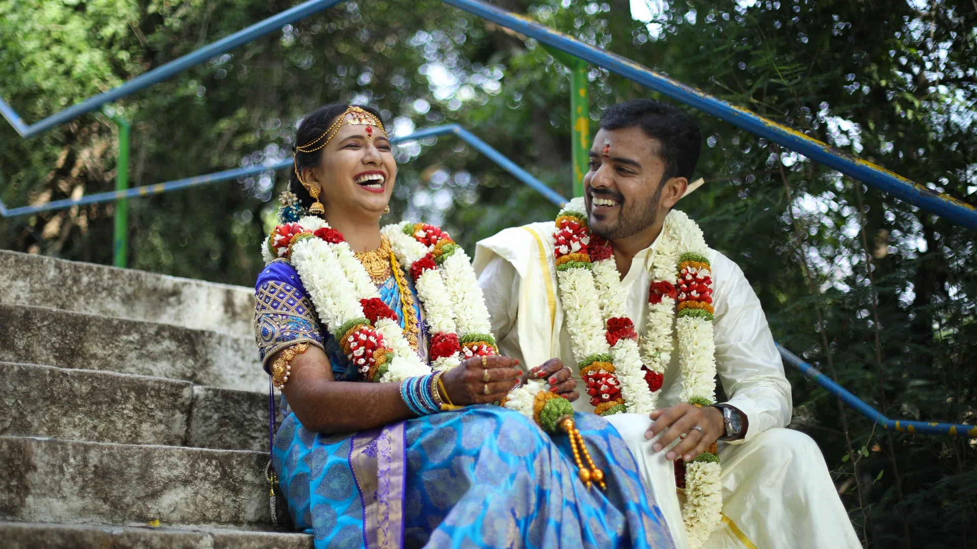 Couple laughing together while seated on outdoor steps