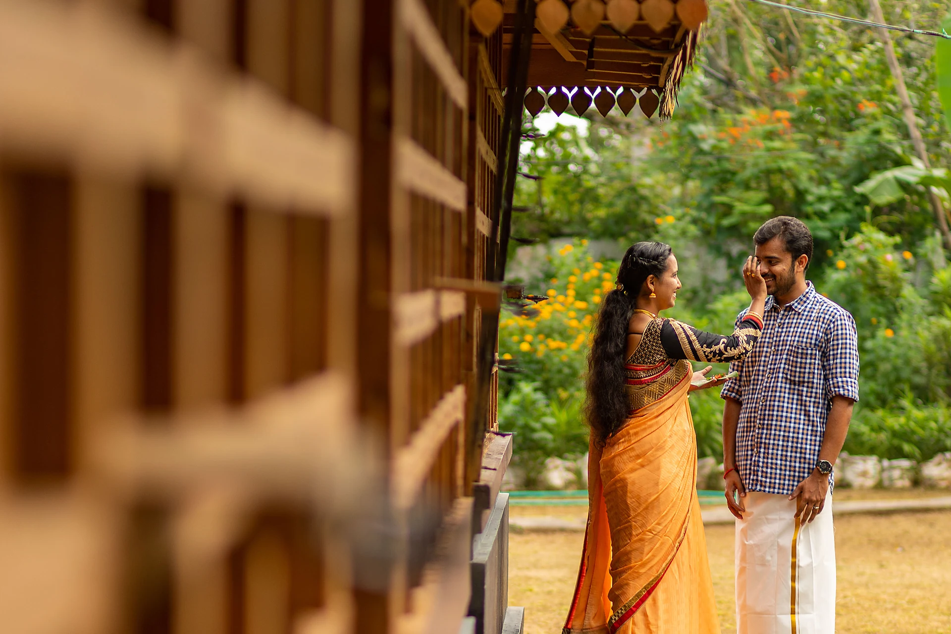 Couple facing each other beside a wooden veranda