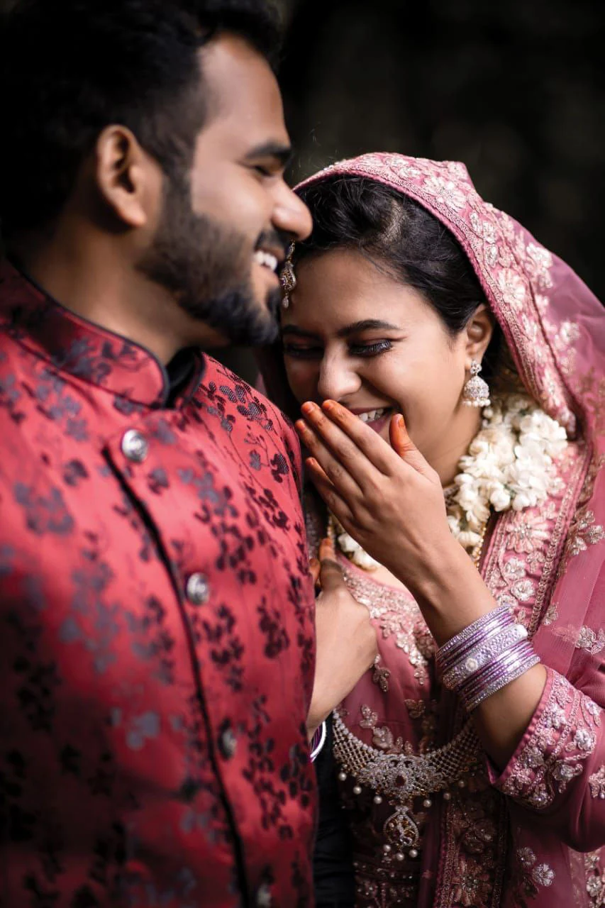 A woman smiling behind her hand while standing beside her partner