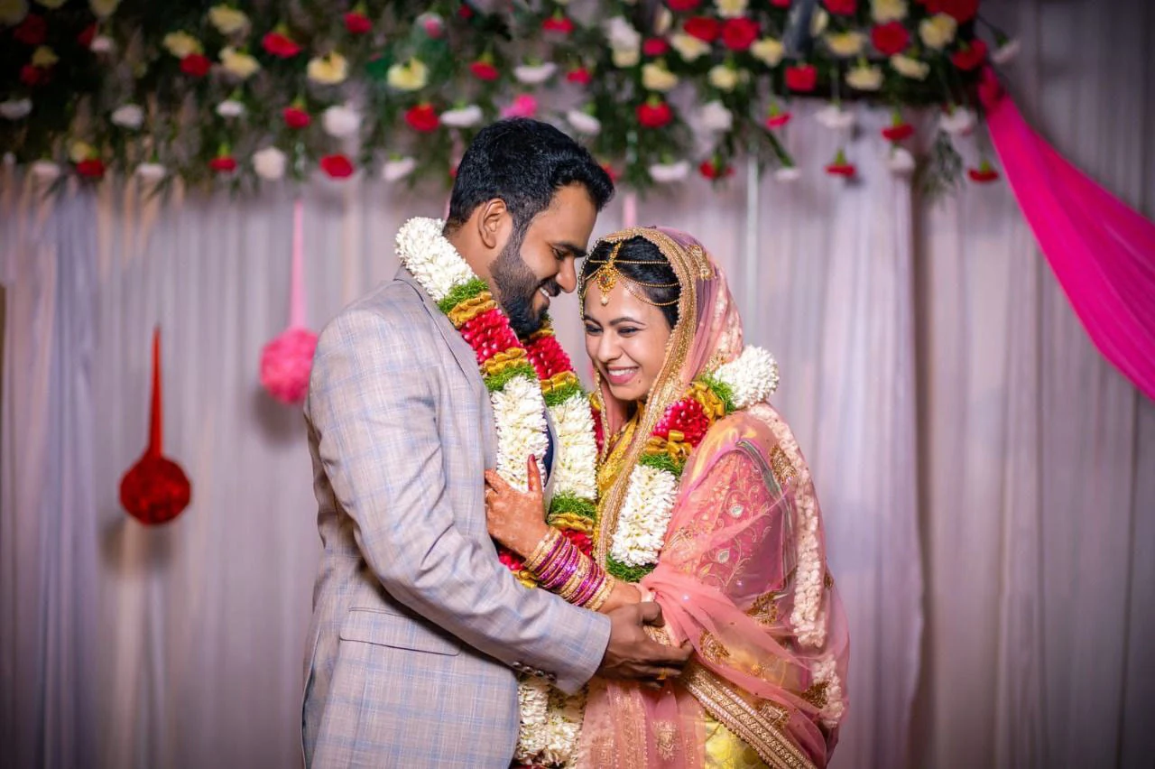 Couple smiling together beneath flowers at their celebration