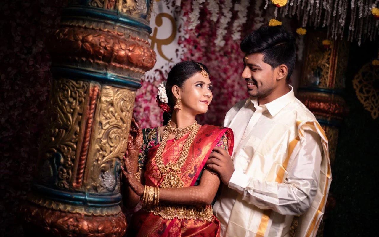 Couple looking at each other beside an intricately carved pillar